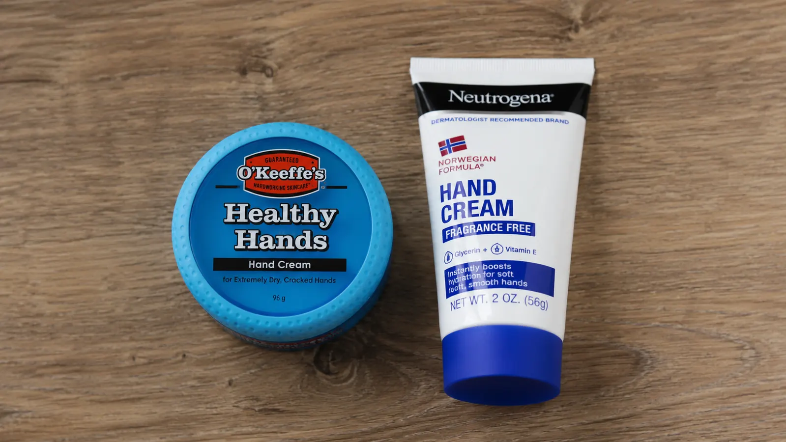 Two hand cream containers, a thick balm jar and a slim tube, set on a kitchen counter with dry winter light through the window